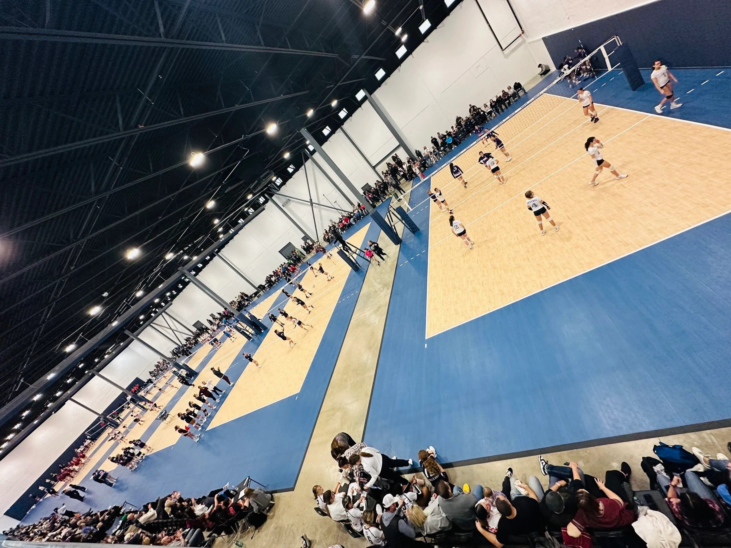 Volleyball tournament play across several courts