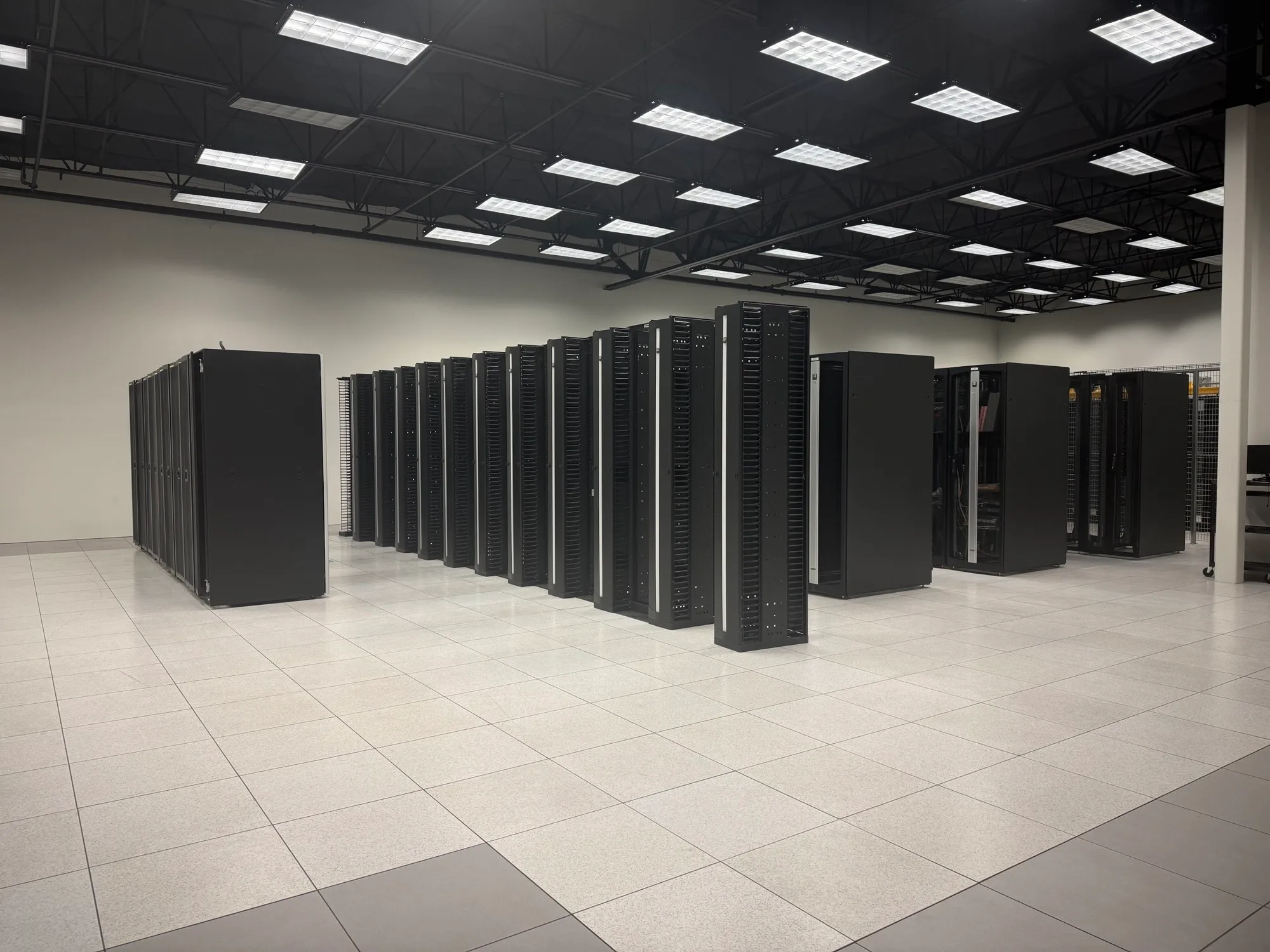 Rows of black server cabinets on a raised floor in the on-site data center